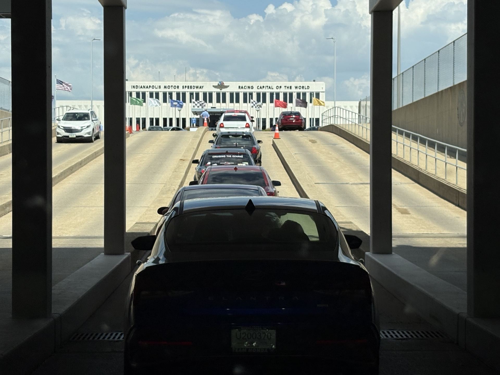 Line of cars driving through a covered inspection lane at Indianapolis Motor Speedway